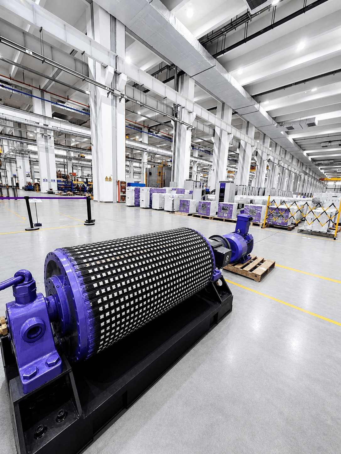 Purple industrial roller machine on a clean factory floor with white pillars in the background.