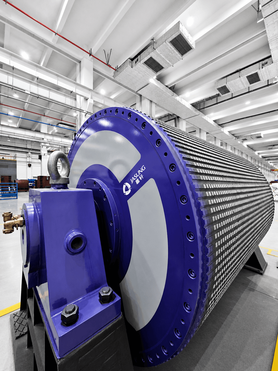 Large blue Jasung industrial drum motor with a textured surface inside a modern factory.